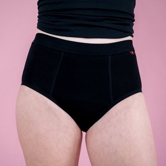 Hey Girls Basic Brief - Black Period Pants worn by a person wearing a black top against a pink background