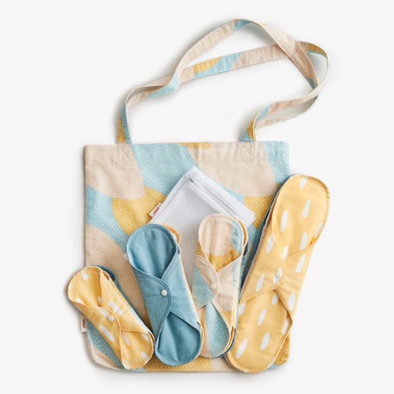 Imse Reusable Period Pads Starter Kit ImseVimse Blue Sprinkle with 8 pads in 4 different sizes, a matching tote bag, and a wash bag on a white background