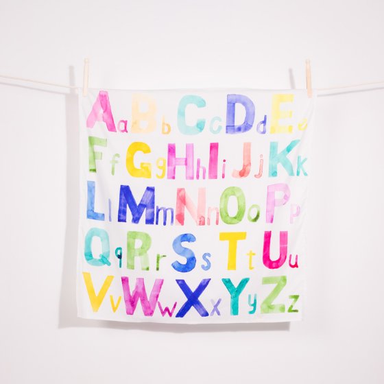 Wonder Cloths organic cotton childrens learning cloth in the alphabet print hanging from a rope line on a white background