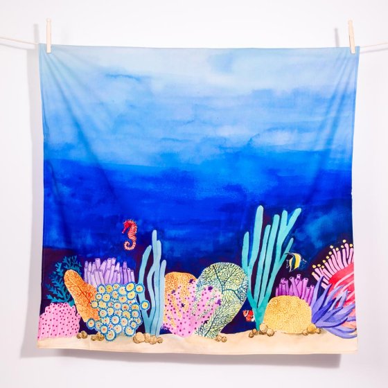 Wonder Cloths eco-friendly childrens play cloth in the coral reef print hanging from a rope line on a white background