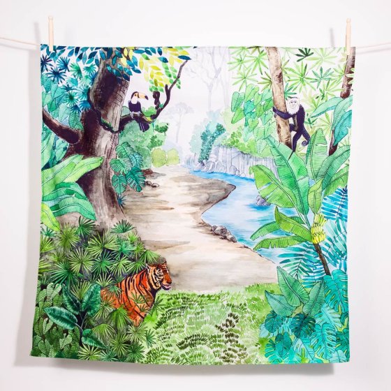 Wonder cloths organic cotton jungle print play fabric hanging from a rope line on a white background