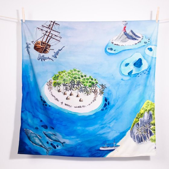 Wonder Cloths organic cotton treasure island play cloth hanging from a rope line on a white background