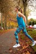 Woman running under some autumn trees wearing the Frugi organic cotton lyra vest top and the cosmo print leggings