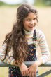 Brunette child wearing Frugi Ava roll neck long sleeve jumper with dungarees