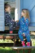 Frug eco-friendly kids big snuggle suit in blue with rainbow coloured birds worn by a girl sat on a step smiling with a boy