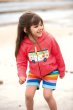 a girl wearing rainbow stripe organic cotton shorts with a stretchy rib waist from frugi