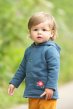 Small toddler wearing the reversible scandi floral jakeet by Frugi on the indigo side with small pink flower applique on pocket