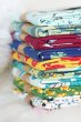 Maxomorra organic cotton craft packs stacked in a pile on a white blanket
