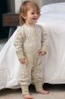 toddler wearing cotton tail footless onesie with a white rabbit all-over print on pale cream and stretchy cream cuffs from piccalilly