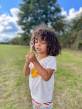 Child blowing bubbles with the small hand wand from the mini bubble kit 