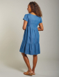 back of a woman wearing maternity chambray dress with the floral applique from frugi
