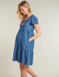 a pregnant woman wearing maternity chambray dress with the floral applique from frugi
