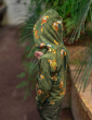 Meyadey Marvellous Macaw, organic, zipped hoodie in rich green with macaw and leaves repeat print. Worn by a young person with dark green trousers. hood up, reverse of child shown