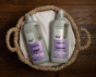 Bio D eco-friendly vegan lavender laundry liquid 1L bottle and conditioner 1 Litre bottle on a white towel, inside a wooden wicker basket