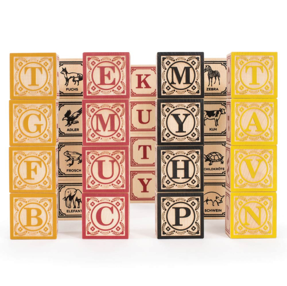 Uncle Goose wooden German language blocks stacked in 7 piles on a white background