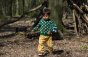 Child wearing LGR snuggly winter forest jumper with yellow gingham trousers in the woods