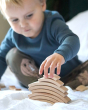 Close up of young boy stacking the Abel curved wooden Golden Ratio toys blocks on a white sheet