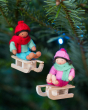 Close up of the Ambrosius handmade sledging boy and girl Christmas decorations hanging from a Christmas tree