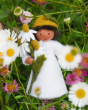 Close up of the Ambrosius eco-friendly felt chamomile fairy figure in some grass surrounded by daisies