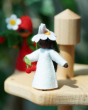 an ambrosius hand felted cherry girl figure placed on the Grimm's wooden festivity stand 