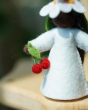 A close up of the cherry details in the hand of the Ambrosius felted cherry girl figure