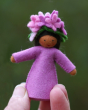 Close up of a hand holding an Ambrosius spring lilac fairy figure on a green background