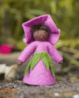 Close up of the Ambrosuis eco-friendly purple morning glory fairy toy on a rock in front of a green background
