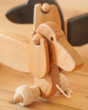 Close up of the handmade natural wooden pull along Bajo dachshund dog on a wooden floor