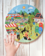 A child's hand hovering over the Bajo Let's Save Our Planet puzzle. The puzzle is placed on a white washed wooden surface 