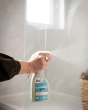 Bio-D natural eco friendly streak free glass and mirror cleaner in a 500ml spray bottle, being sprayed onto glass