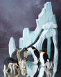 Ostheimer and Bumbu penguin figures placed on a reflective surface with the Bumbu icy cliffs seen in the background