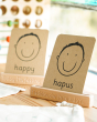 Coach House Welsh emotions flashcard stood in the Welsh emotion flashcard stand on a wooden worktop in front of a window
