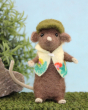 Gardening mouse is keeping busy in the garden! A beautifully crafted brown mouse wearing a green hat and floral gardening coat, stood on a grassy floor with a blue background