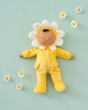 Olli Ella Dozy Dinkum Doll - Lavender Pickle in a soft velvet petal lavender onsie, sleepy eyes and a brown tuft of hair, on a green background with daisies