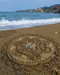 A mandala shape in the sand created using the bamboo tools for the Dr Zigs beach creativity set 