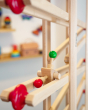 Close up of the Fagus click click marble run toy rolling down a Fagus wooden marble run set
