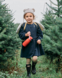 A happy child walking through a pine forest holding their One Green Bottle 350ml Evolution Collection Bottle - Sports Cap in Coral