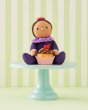 Freya Fondant is sat on a cake stand behind a delicious cupcake, on a green and white stripe background