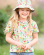 Young girl stood wearing the Frugi organic cotton floral shirt