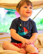 Young girl sat on a blanket wearing the Frugi organic cotton mermaid fearne pyjamas