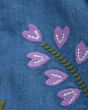 Close up of the purple embroidered flowers on the Frugi eco-friendly emma chambray dress