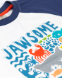A close up of the Jawsome print of the Frugi Reid Raglan T-Shirt - Jawsome. A colourful t-shirt made from GOTS Organic cotton  with a white body with sea-life animal print, and navy short sleeves