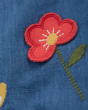 Close up of the red embroidered flower on the blue Frugi emma chambray dress