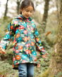 Young girl walking through the woods wearing the Frugi eco-friendly childrens waterproof rain jacket