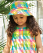 A child gazing downwards, wearing the Frugi Organic Sorrel Reversible Hat - Summertime Check, which shows a little bit of the light blue underneath, and a Summertime Check outfit