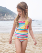 A child happily playing on the beach, wearing the Frugi Kiri Tankini - Sunshine. A beautiful and clolourful sunshine striped print tankini, bottoms and top set with cross over back and soft lining. Made with Recycled material.
