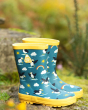 Frugi childrens eco-friendly puffin puddle buster wellington boots on a rock in front of some green grass
