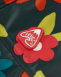 Close up of the rubber Frugi logo on the floral print rainy days waterproof jacket