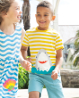 A child happily playing with their friend on a sunny day, wearing the Frugi Children's Organic Cotton Sid Applique T-Shirt - Shark. 