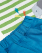 A closer look at the stitching and material on the blue shorts of the Frugi Organic Easy On Wrap Around Outfit - Kiwi Stripe / Elephant. The green and white stripe t-shirt with Elephant is in the background